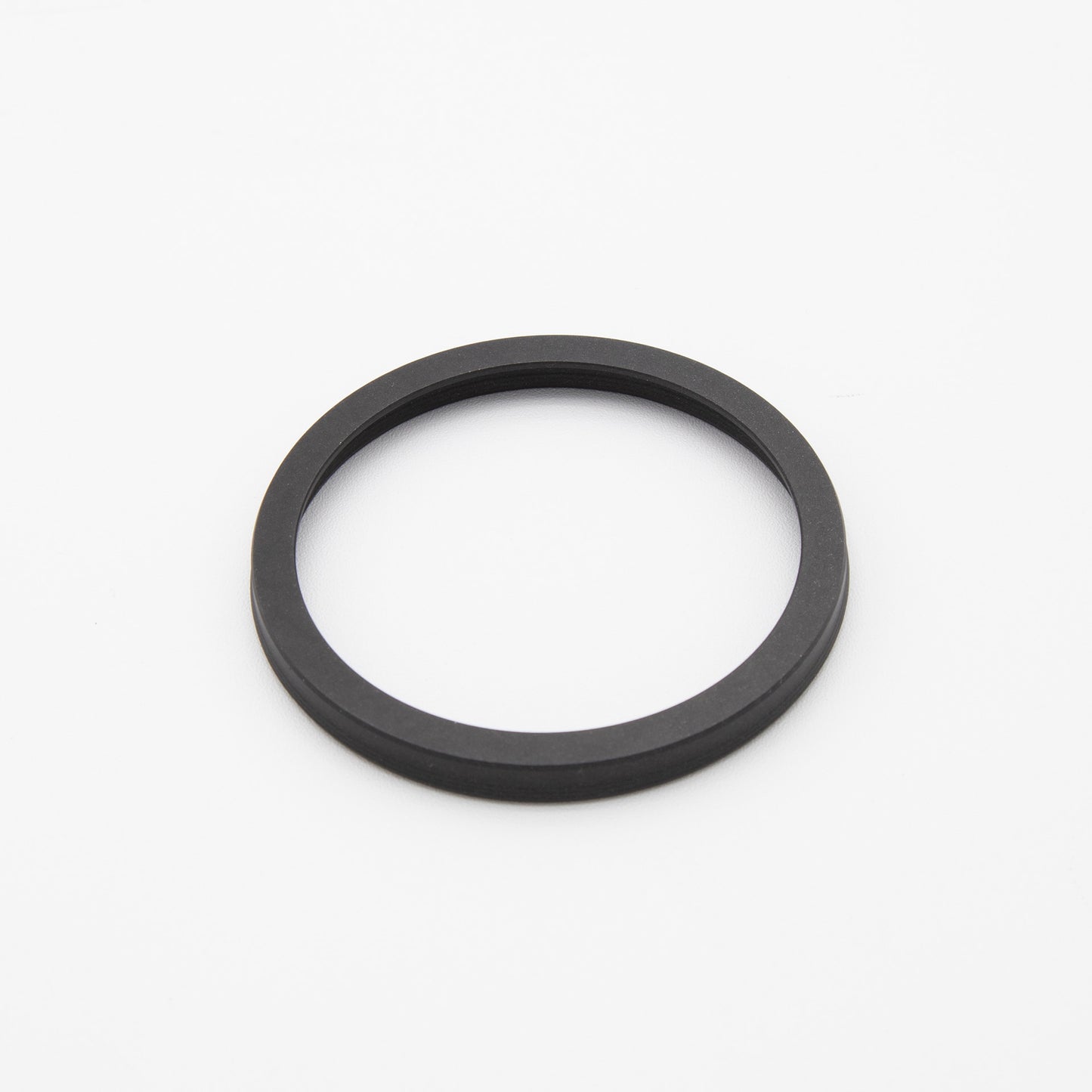 Black rubber ring placed on a clean white surface, showcasing the circular shape and smooth texture.