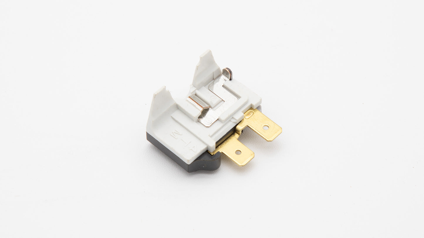 A white and gold switch placed on a smooth white surface, emphasizing a minimalist and refined look.