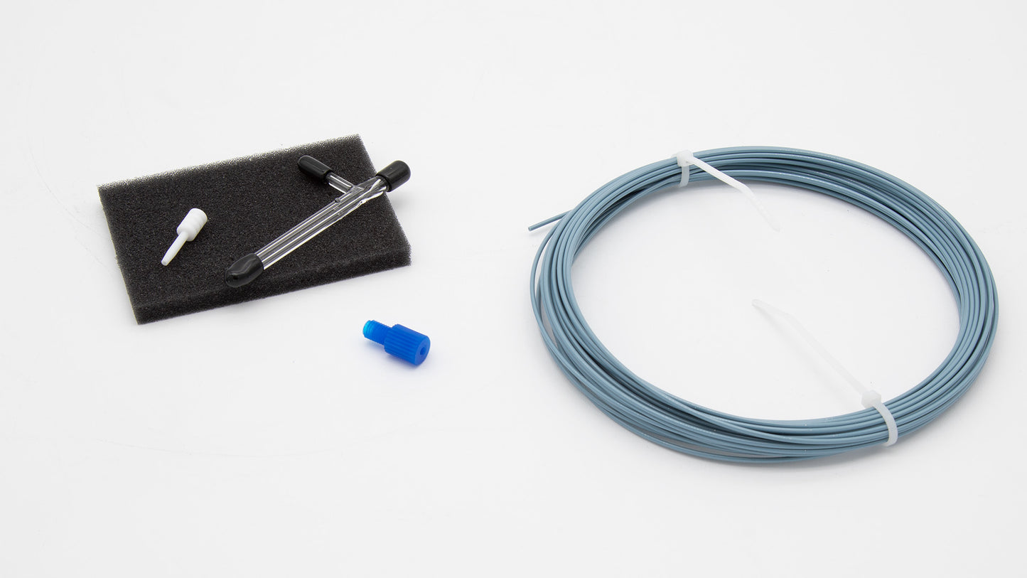 A roll of blue tubing and a other components are placed on a clean white surface, showcasing their distinct colors and textures.