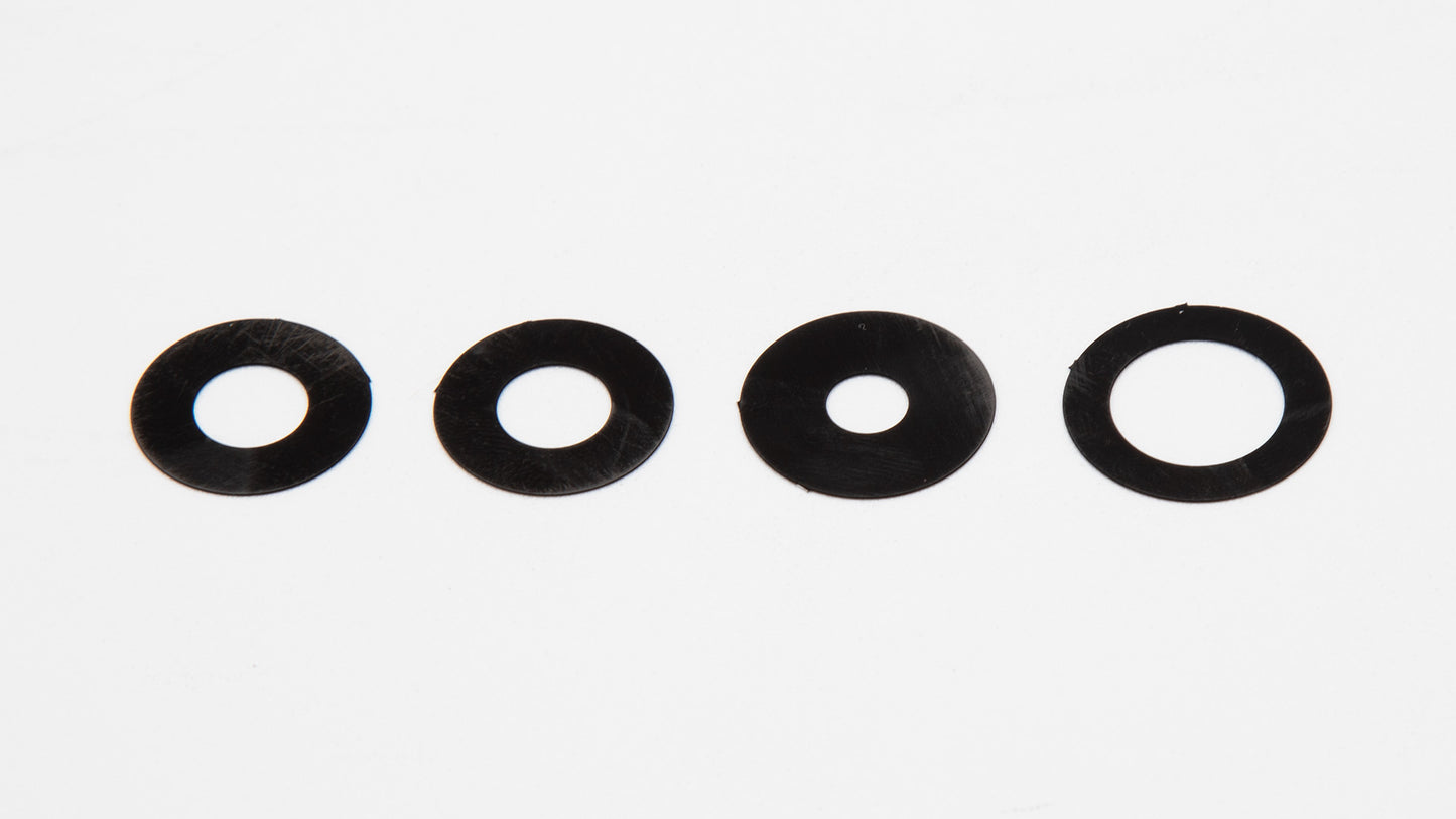 A set of four circular shaped black plastic object displayed on a white surface, emphasizing their round form and contrasting color.