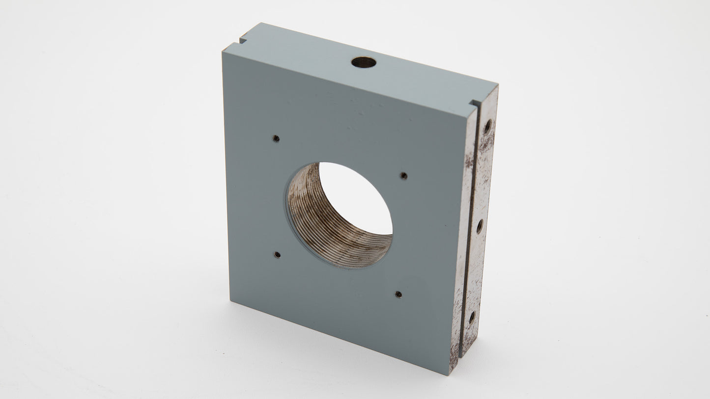 A circular metal plate with a prominent threaded hole at its center, highlighting its functional and aesthetic qualities.