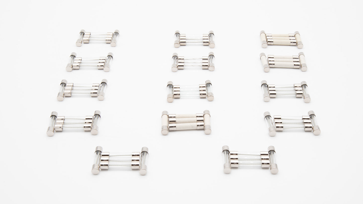 A set of 14 different fuses positioned on a white surface, showcasing their sleek design.