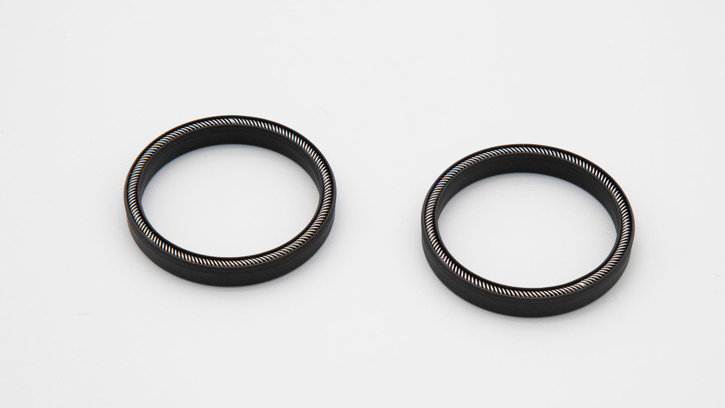 Two black rubber rings placed on a clean white surface, showcasing their circular shape and smooth texture.