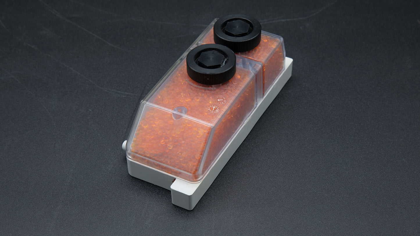 A close-up view of a small box containing orange beads, highlighting its intricate details and colors.