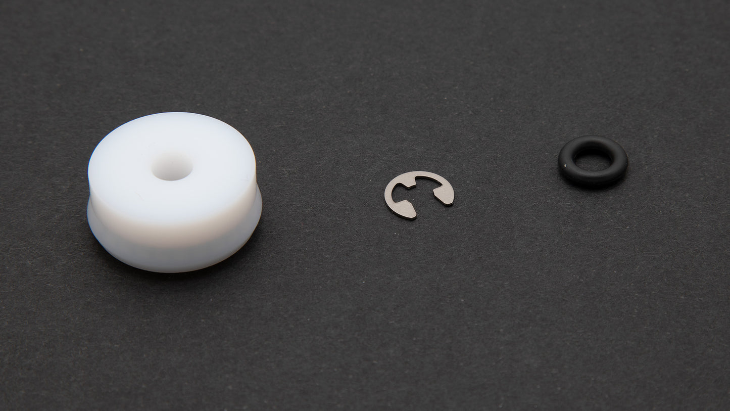 A black ring alongside a white ring, showcasing a stainless steel retaining ring.