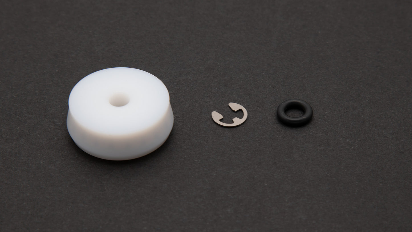 A black ring alongside a white ring, showcasing a stainless steel retaining ring.