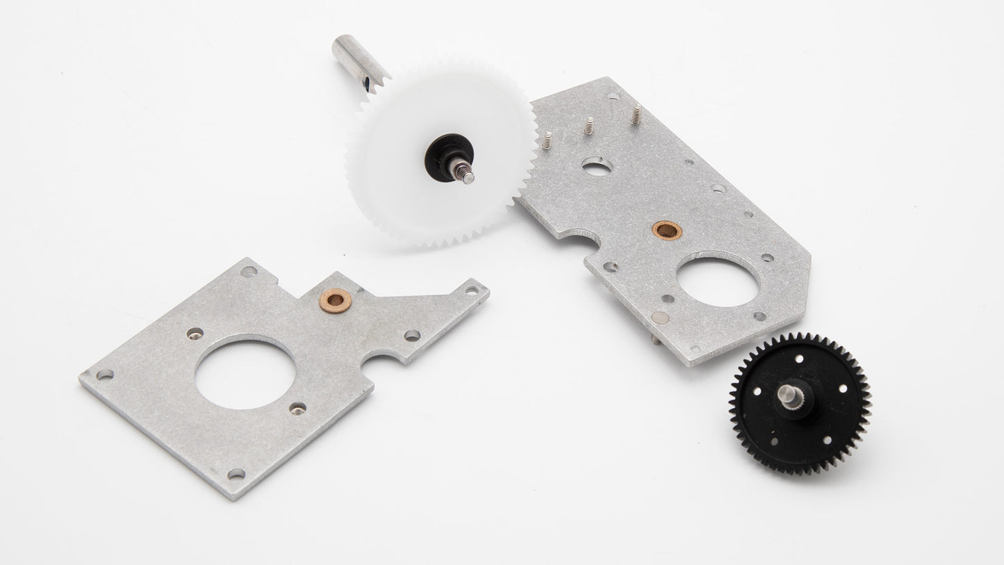 A pair of gears and steel plates arranged on a clean white surface, showcasing mechanical components.