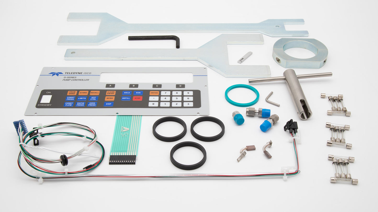 A collection of components featuring a keypad, wrench set, seals, fuses and other items on a clean surface.