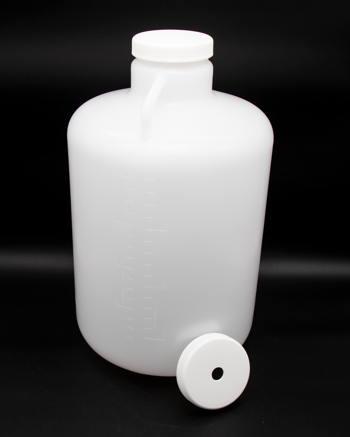 A plastic container with caps, positioned against a solid black background, highlighting its shape and texture.