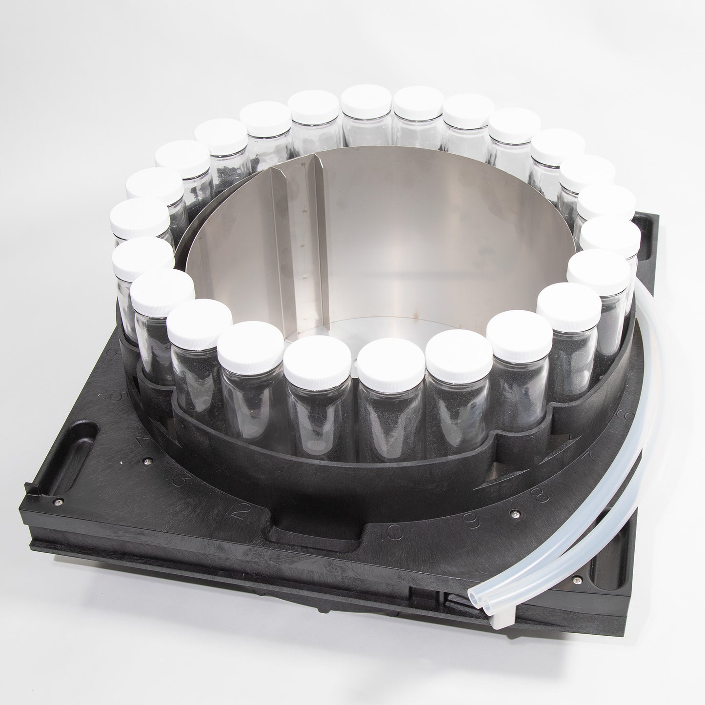 A circular container supporting several bottles arranged neatly on its surface.