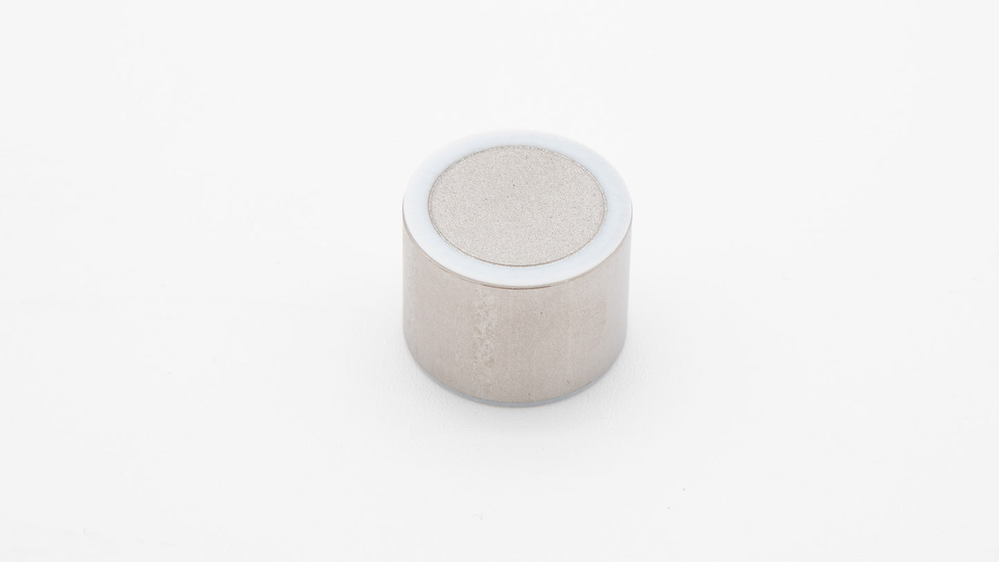 A shiny silver object placed on a smooth white surface, highlighting its metallic luster.