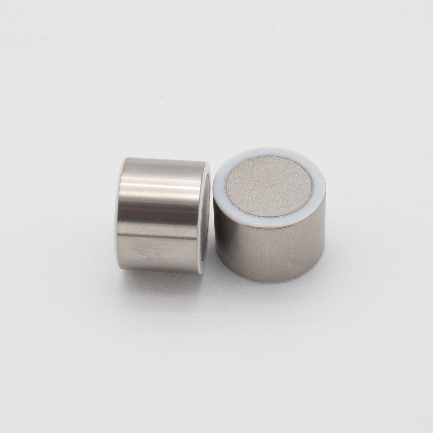 Two small metal cylinders, showcasing a sleek and modern design.