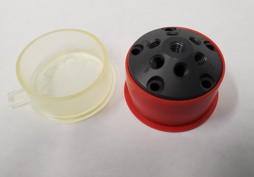 A red and black plastic stator featuring multiple connection points throughout its surface.