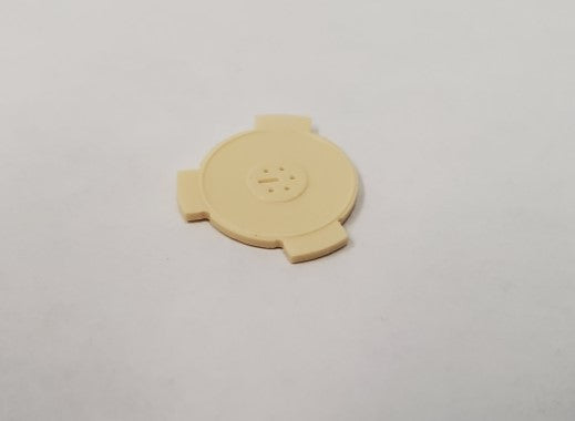 A small rotor featuring a circular design with three protruding spots.