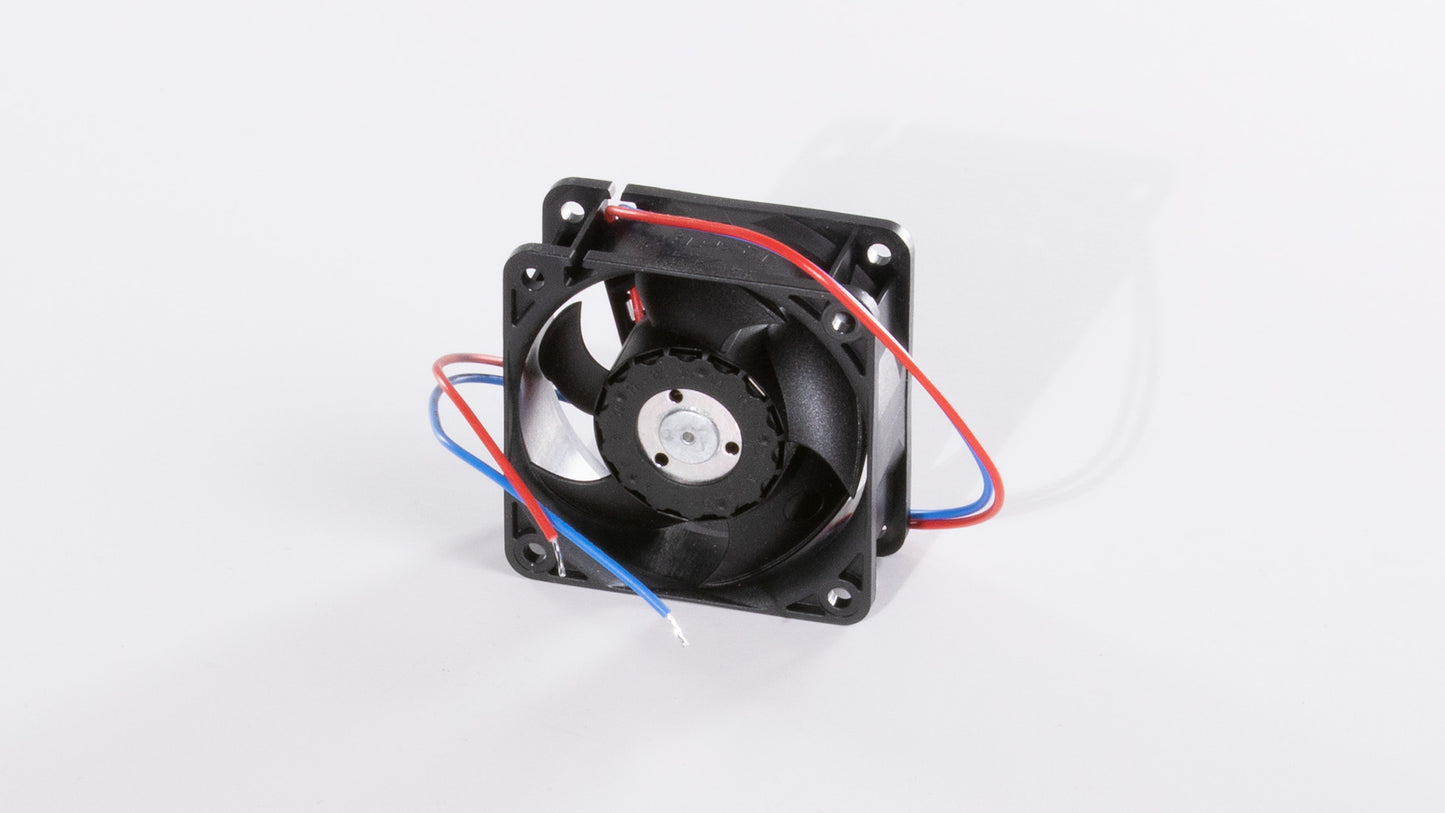 A small black fan positioned on a clean white surface, showcasing its sleek design and compact size.