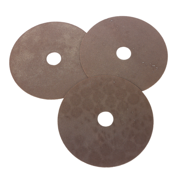 Three circular brown discs displayed on a solid black background, highlighting their texture and form.