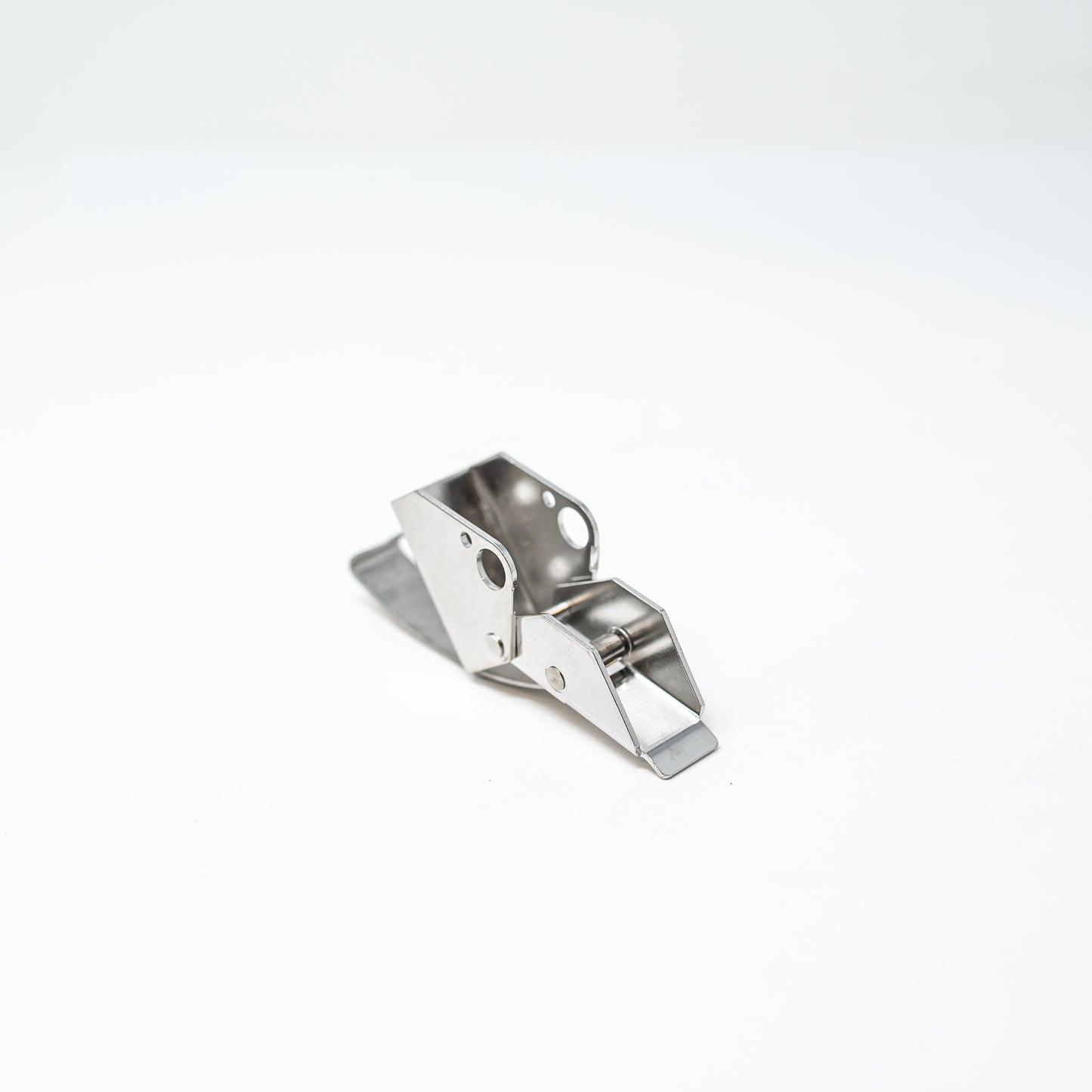 A silver metal latch placed on a white surface, emphasizing its polished appearance and simple elegance.