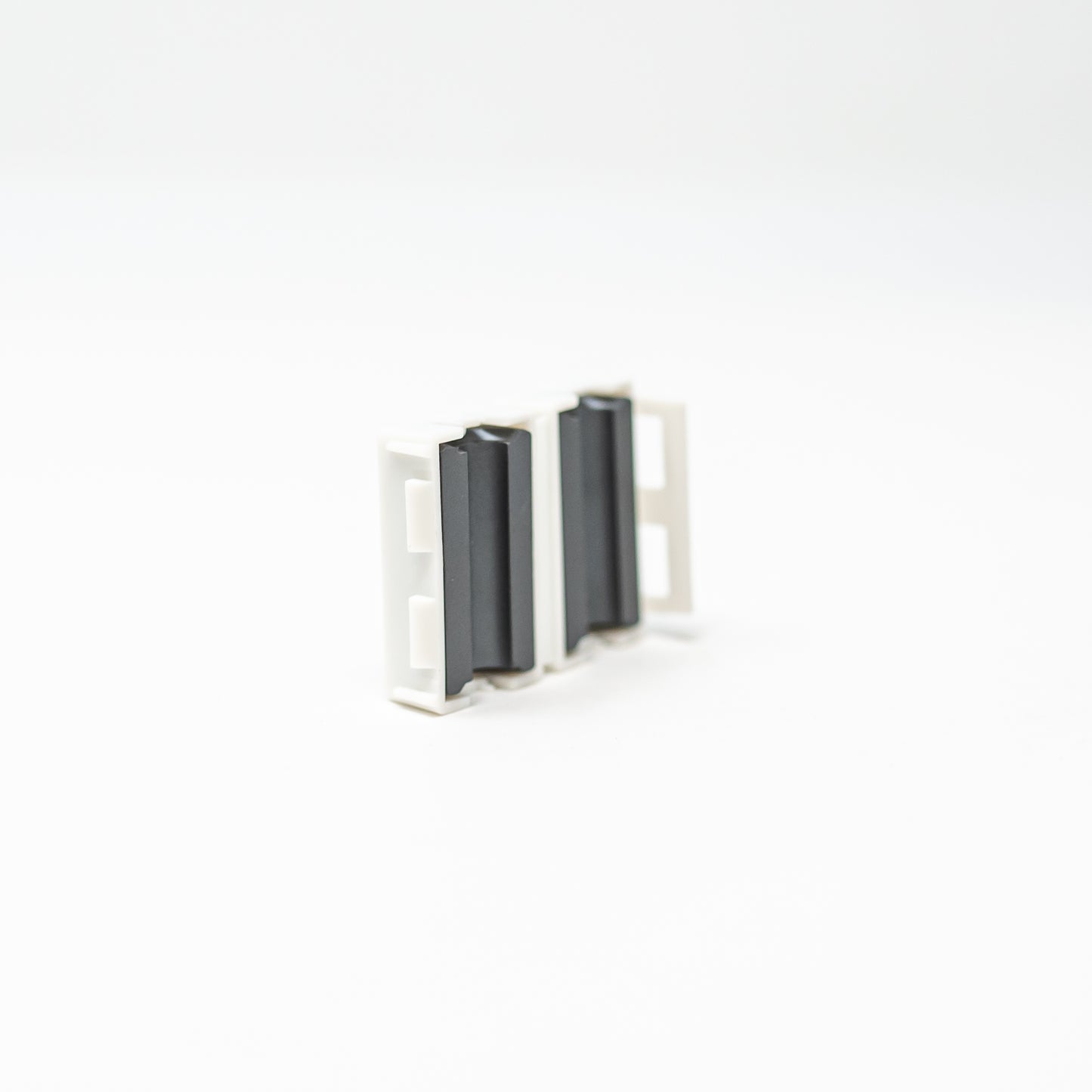 A close-up view of two black and white metal clips, showcasing their design and texture against a neutral background.
