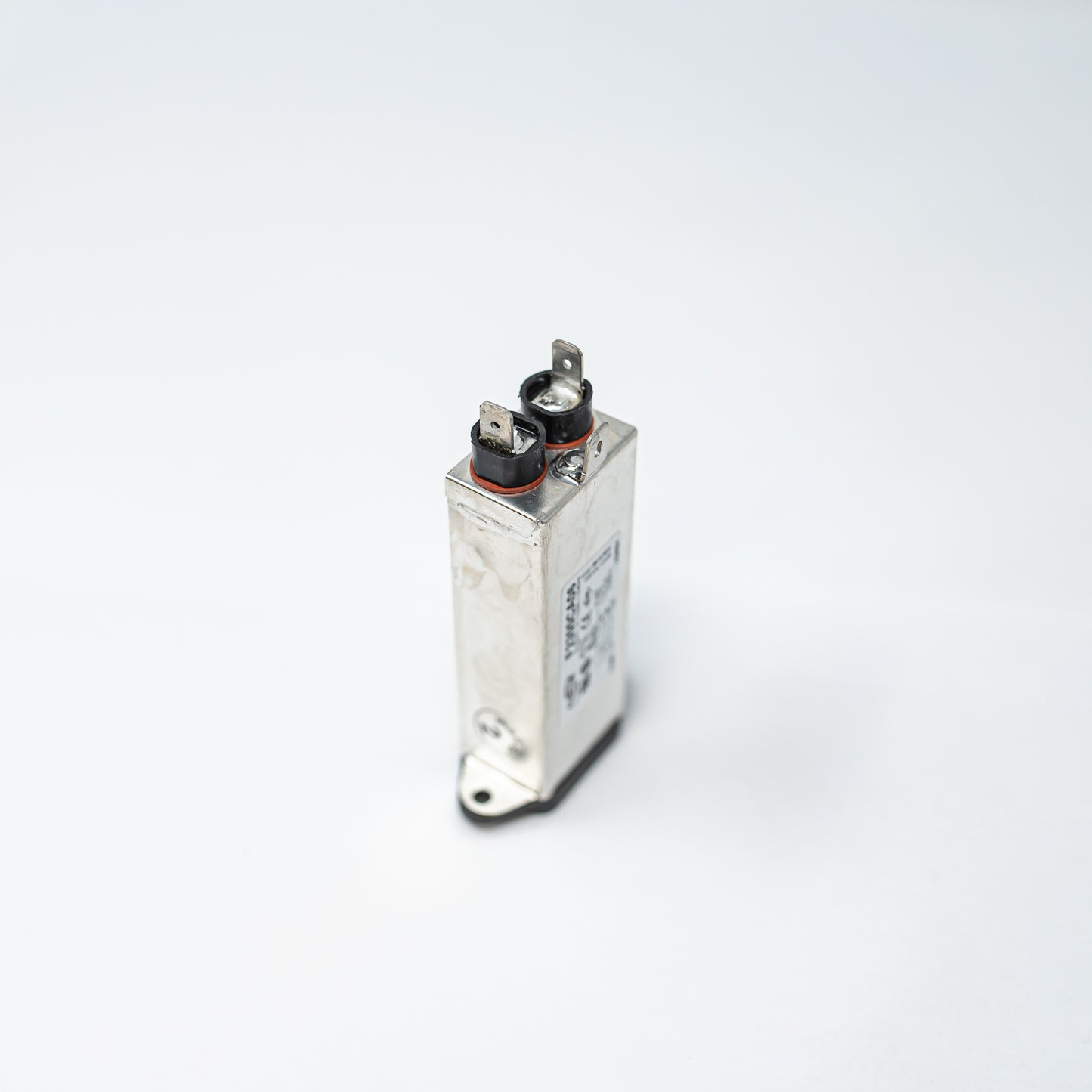 A small metallic filter with two prongs, representing a straightforward device for electrical connections.