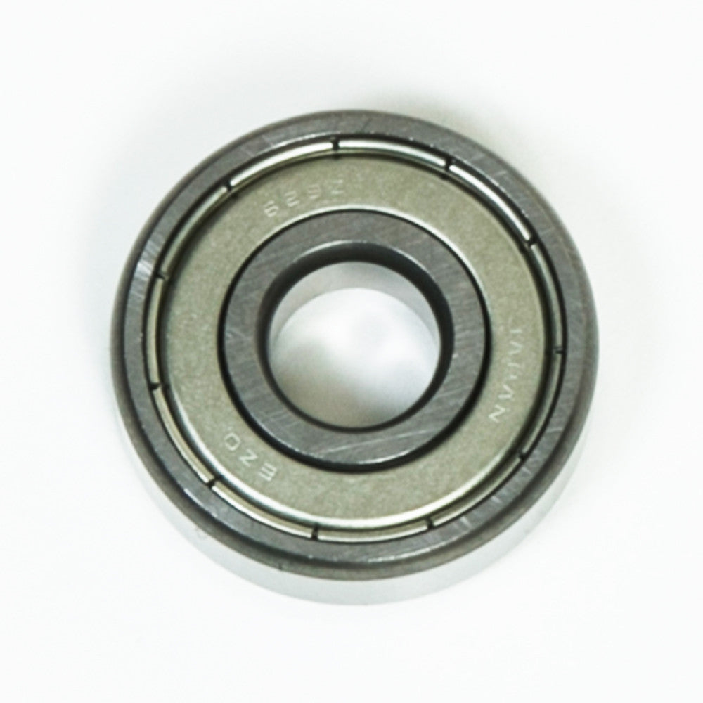 A close-up view of a bearing placed on a white background, showcasing its cylindrical shape and metallic finish.