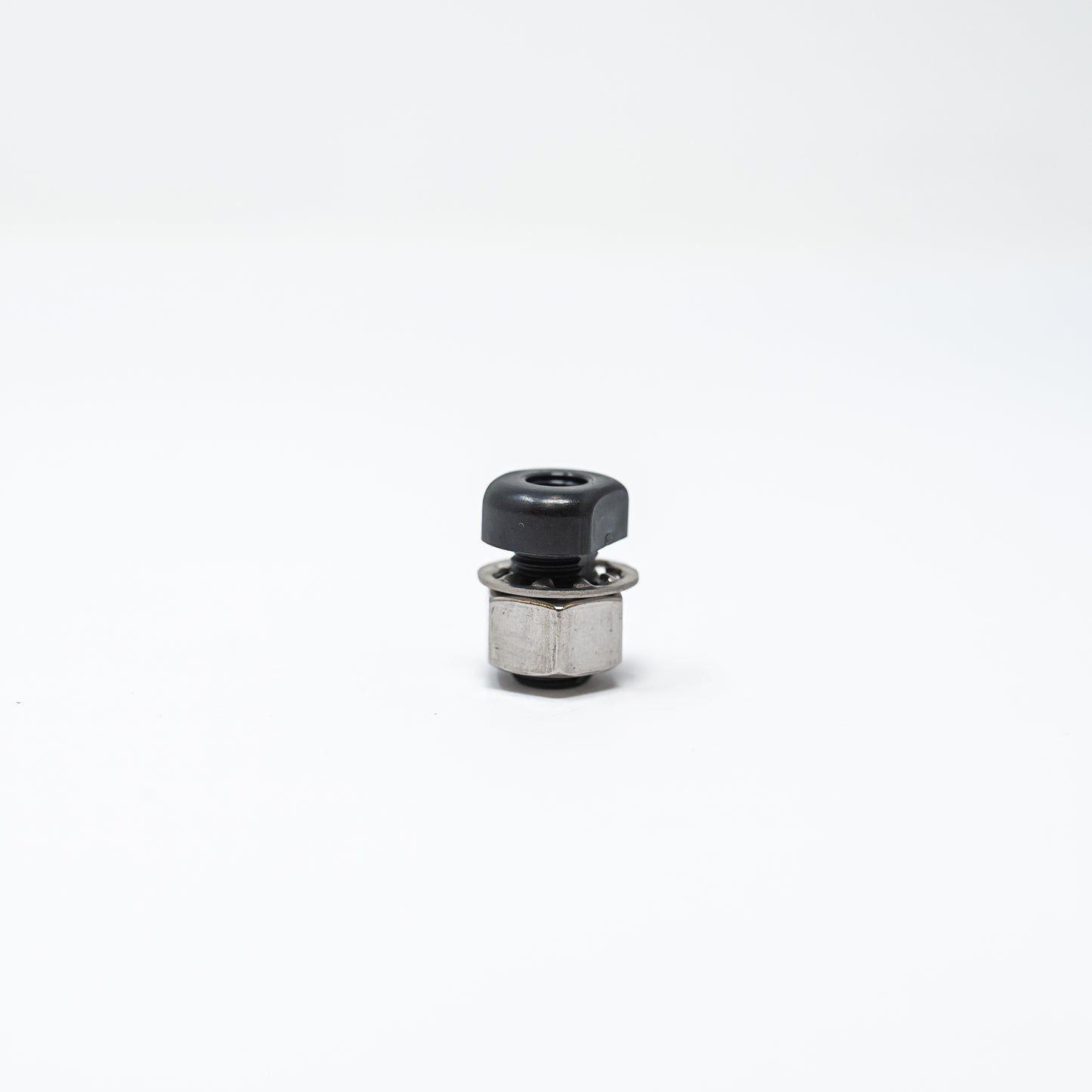 A small black and silver metal object resting on a clean white surface, showcasing its sleek design and contrasting colors.