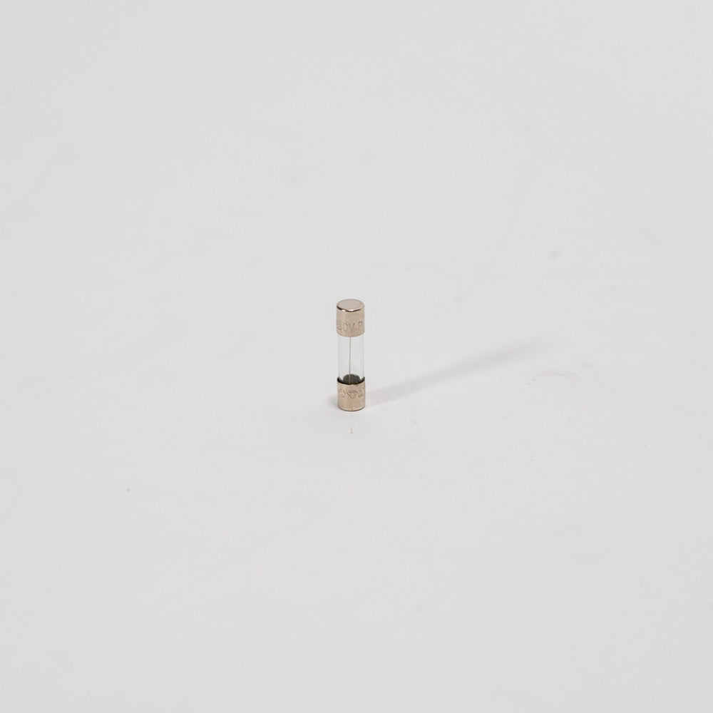 A compact electronic fuse positioned on a white surface, highlighting its sleek design.