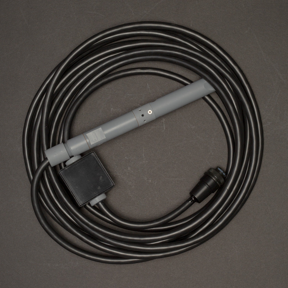 A black cable connected to a cylindrical grey cylinder, showcasing a simple electronic setup.