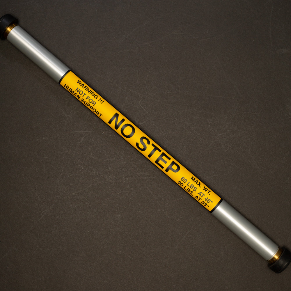 A metal pole with a clear "No Step" sign attached, instructing individuals not to step on the pole.