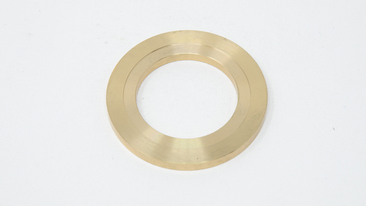 A brass-colored ring resting on a smooth white surface, showcasing its metallic sheen and elegant design.