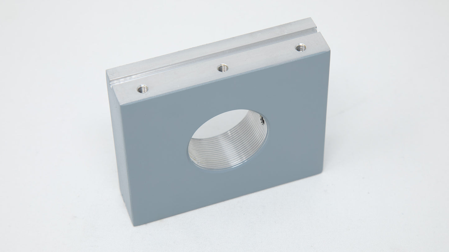 A gray square metal plate featuring four evenly spaced holes for mounting or fastening purposes.