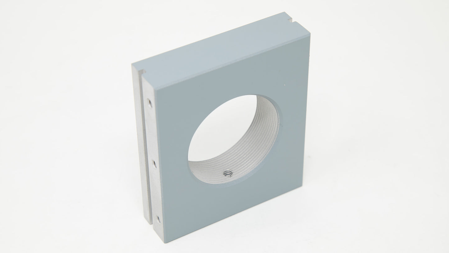 A gray square box featuring a circular hole in the center, showcasing a minimalist design.