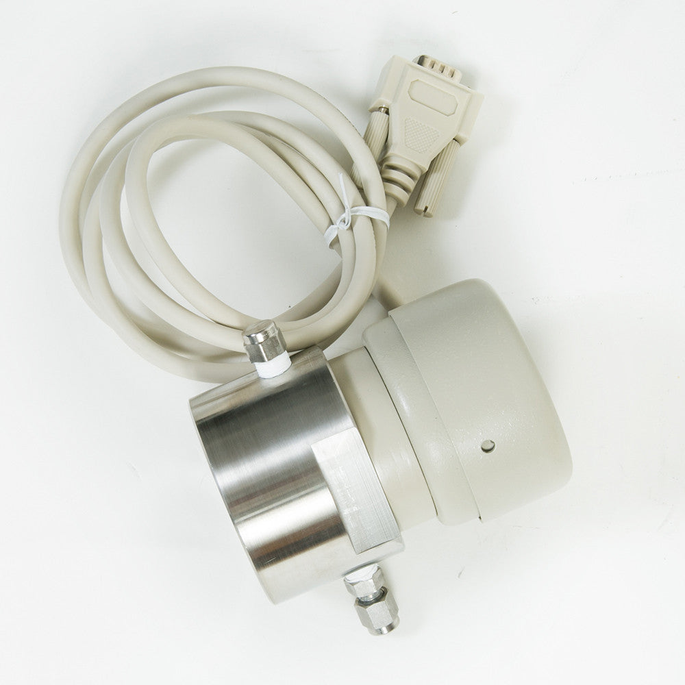A cylindrical shaped device featuring a cord, positioned on a surface, suggesting it is powered or connected to another device.