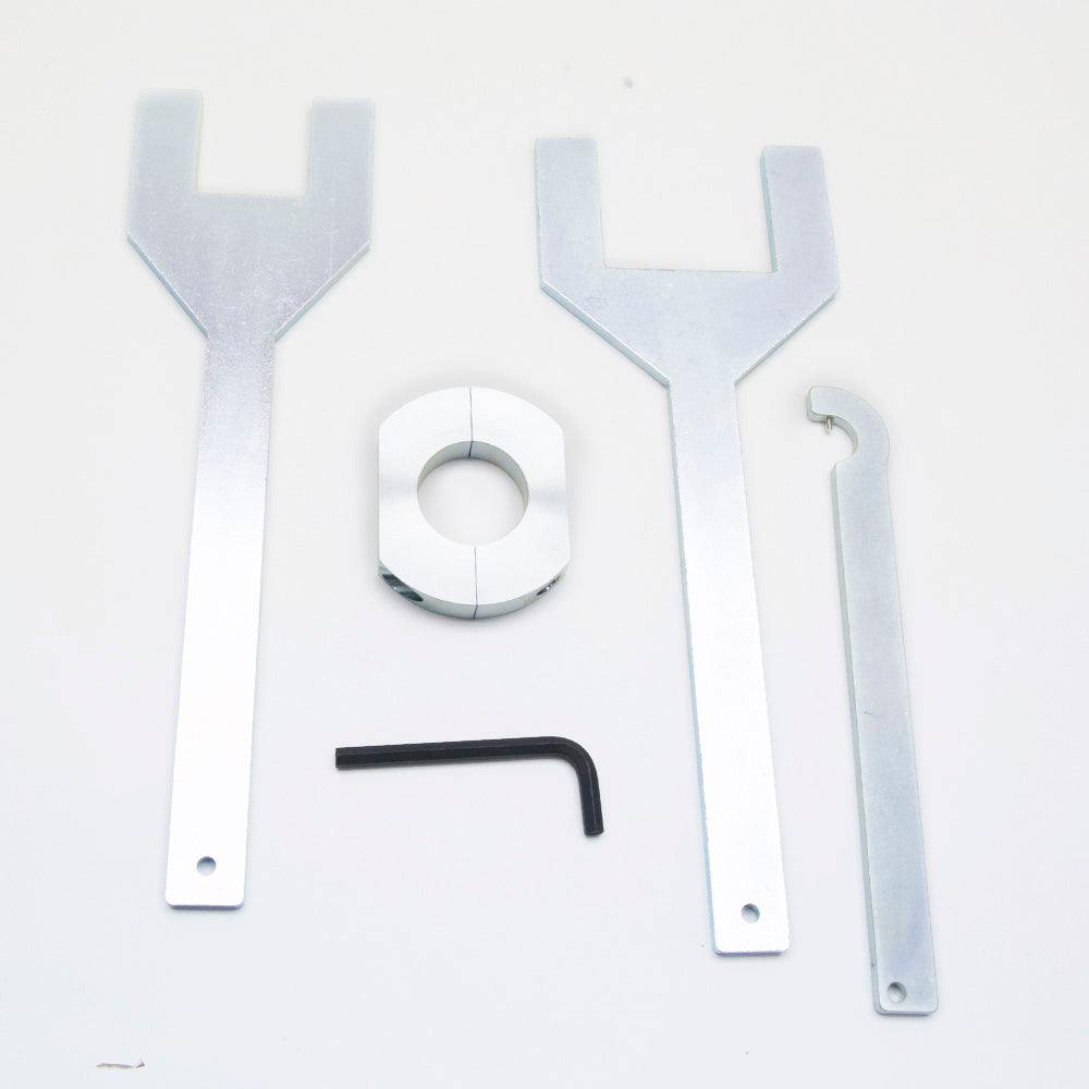 An assortment of steel objects consisting of wrenches and a hex key placed on a flat surface.
