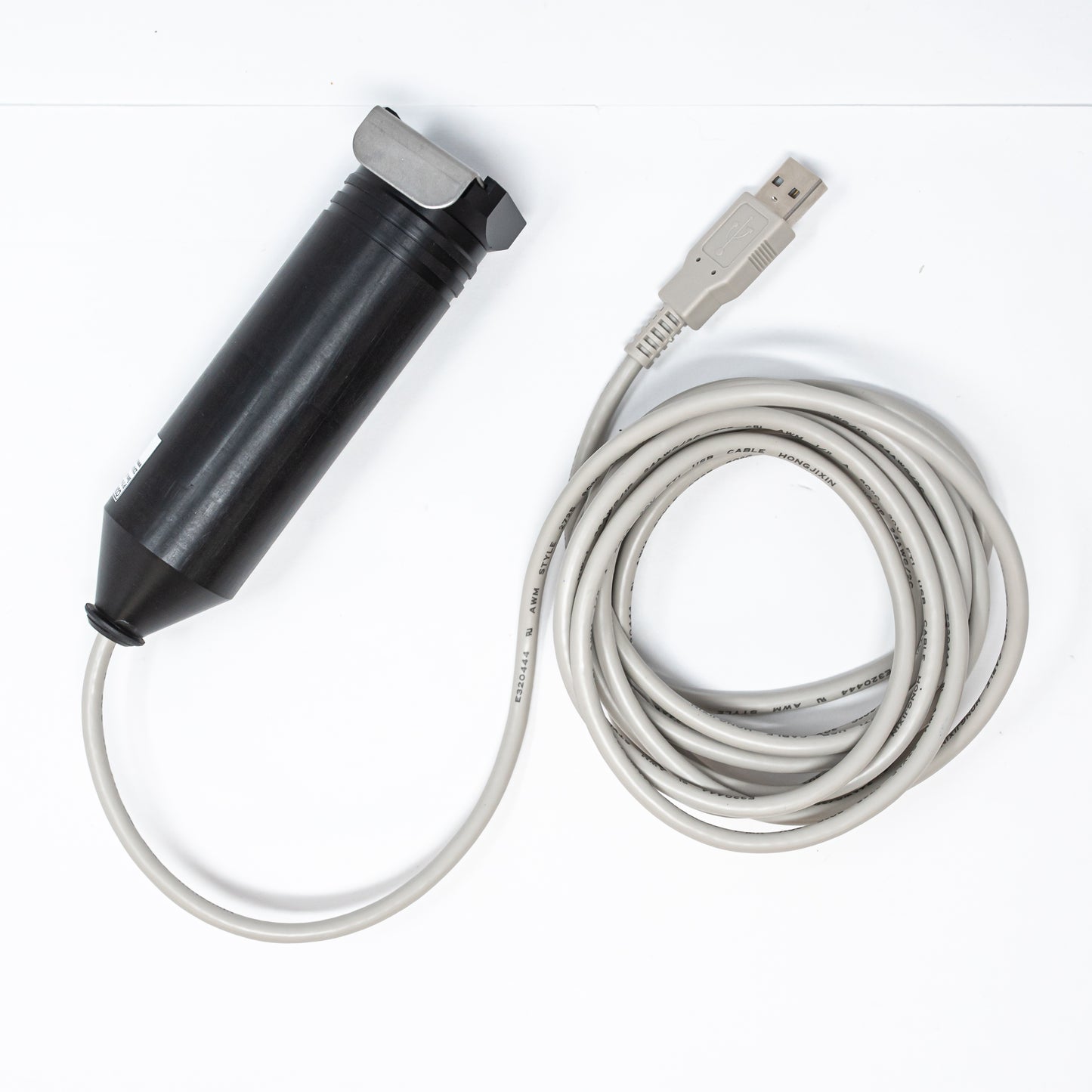 A black cylindrical shaped device with a tan USB cord attached, emphasizing a clean and efficient connection between the two elements.