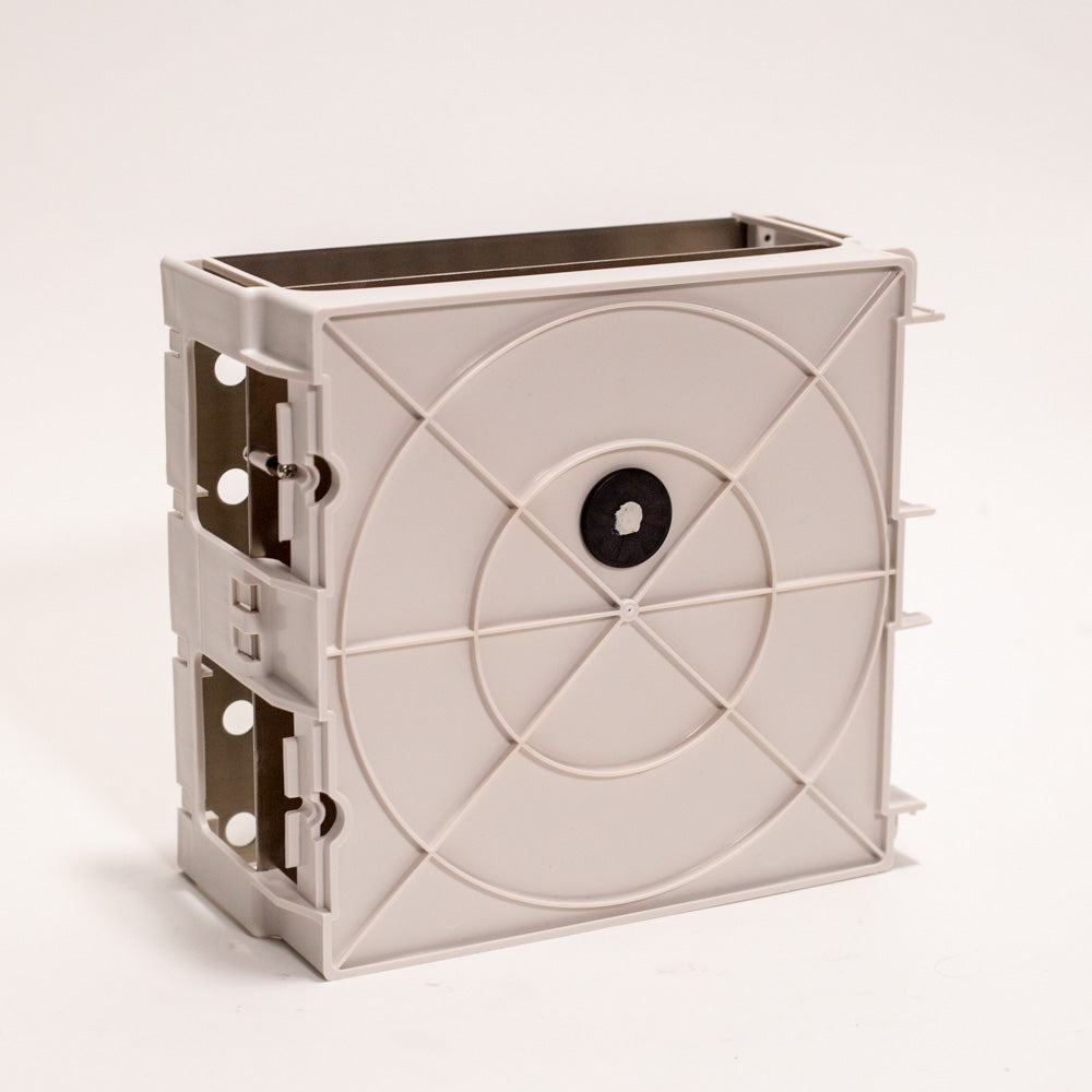 A white plastic box featuring a prominent black circle on its surface.