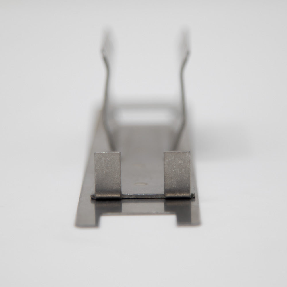 A metal plate that includes a hole intended for a screw, facilitating secure attachment.