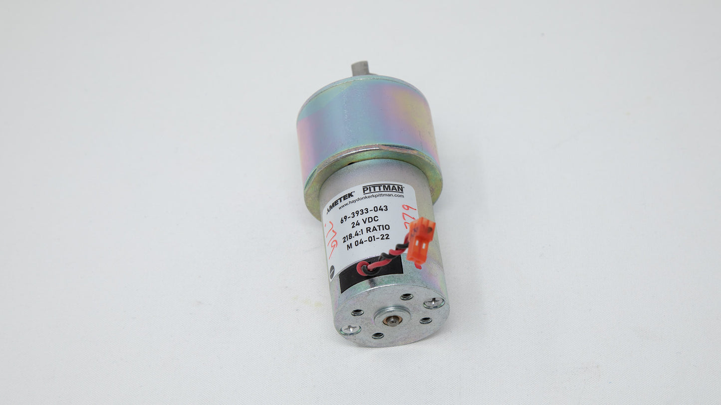 A small motor connected to a wire, showcasing its compact design and functionality in a mechanical context.