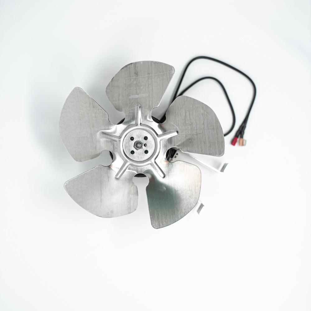 A polished metal fan situated on a bright white surface, illustrating its modern look and practical use.