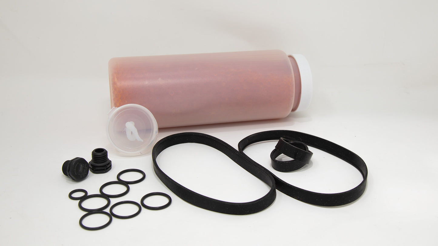 A clear plastic container with orange colored beads and displaying an assortment of rubber rings and washers, highlighting their utility and design.