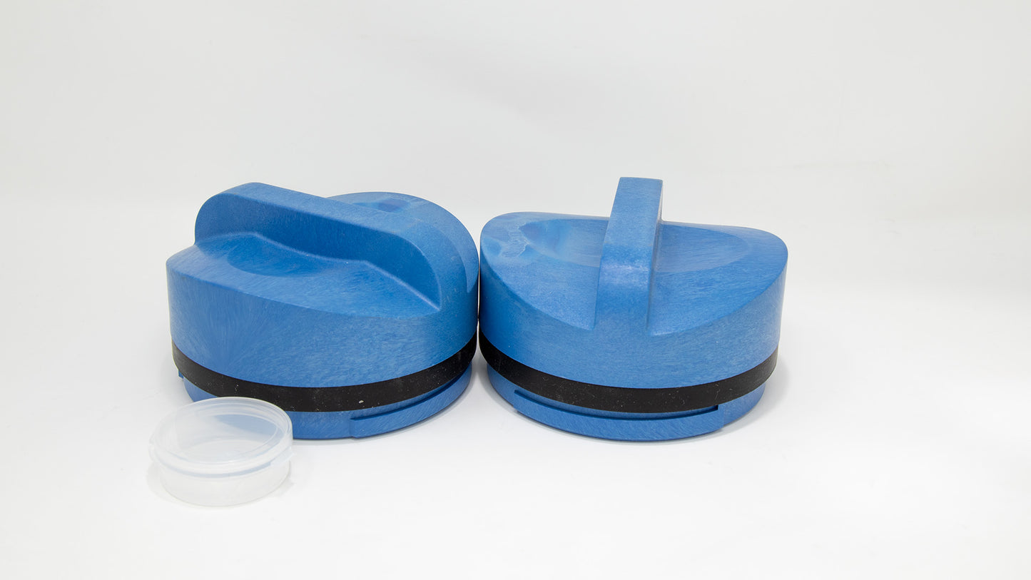 Two blue plastic caps placed on a clean white surface, showcasing their vibrant color and simple design.