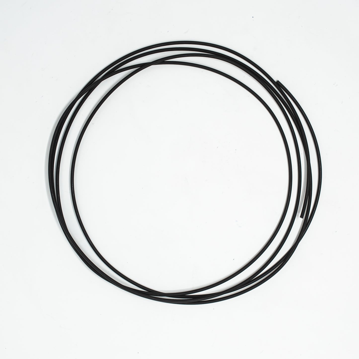 A roll of black tubing positioned against a clean white background, showcasing its smooth texture and flexible design.