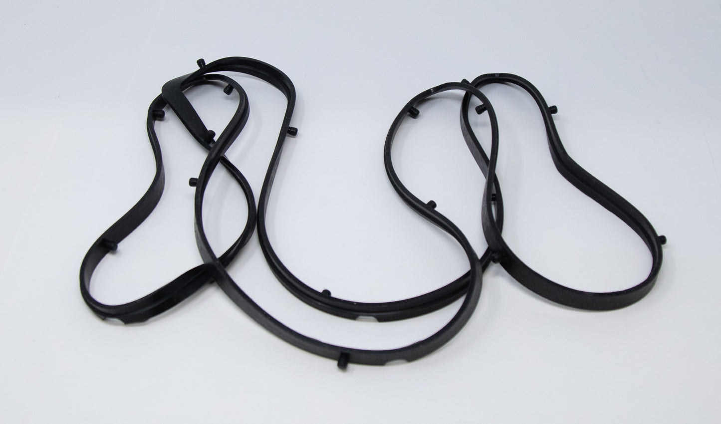 A pair of black rubber bands resting on a clean white surface, showcasing their simple and functional design.