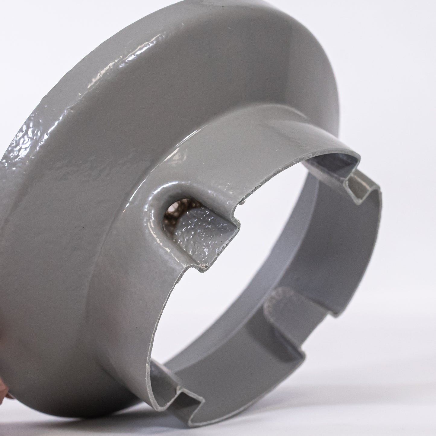 A gray circular plastic object, emphasizing the details of the surface.