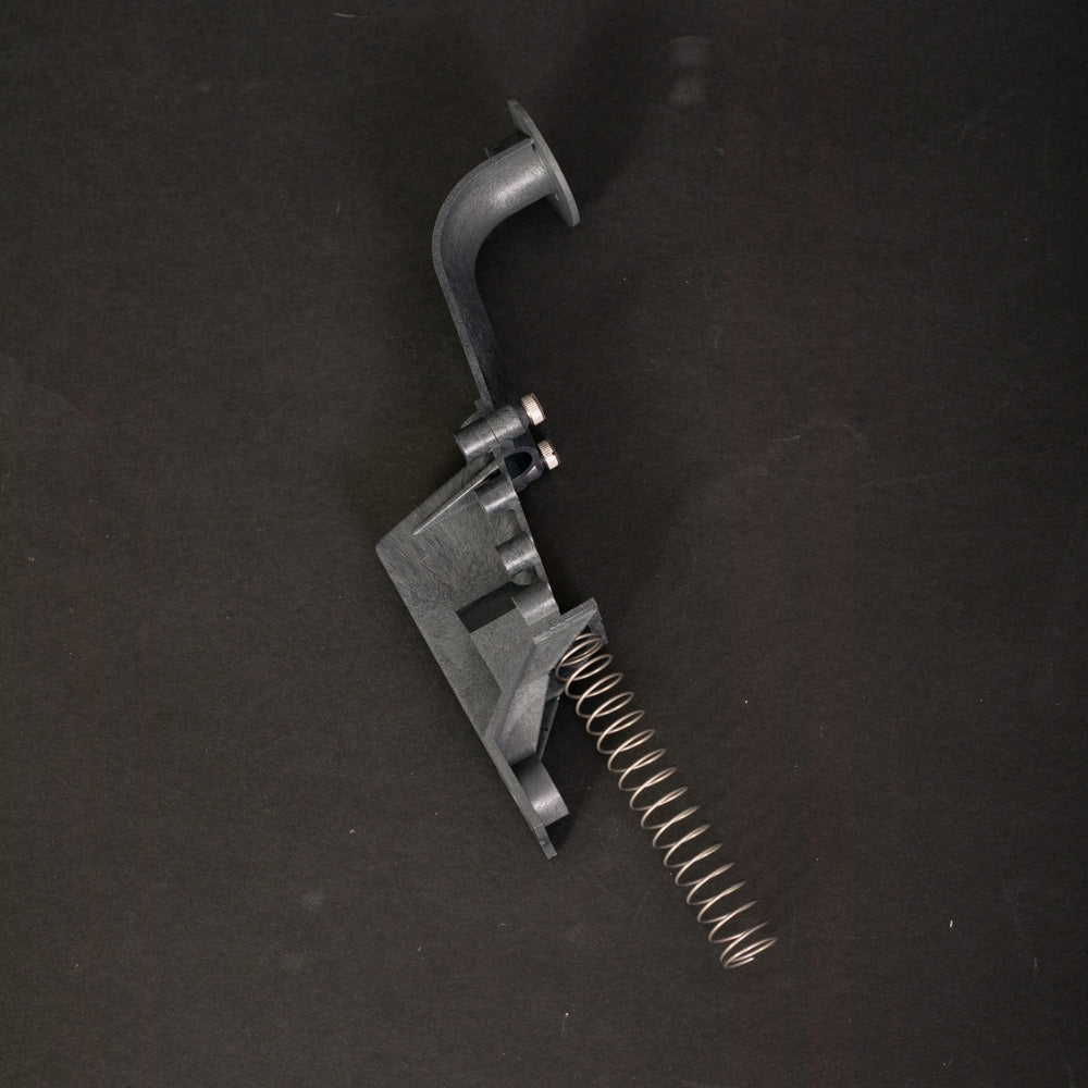 A small plastic object featuring a coiled spring, showcasing its compact design and mechanical functionality.