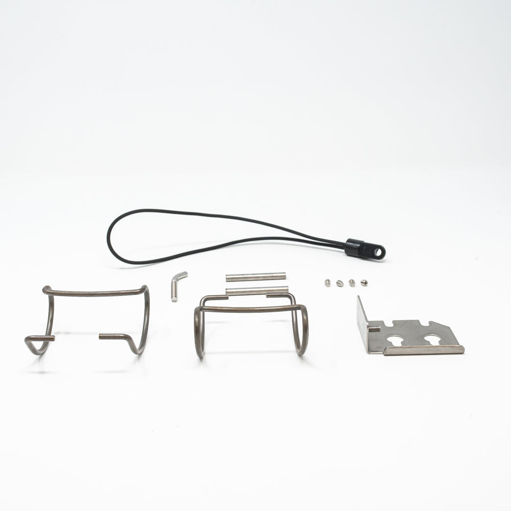 A display of metal items, including a pair of metal clips positioned together on a simple surface.