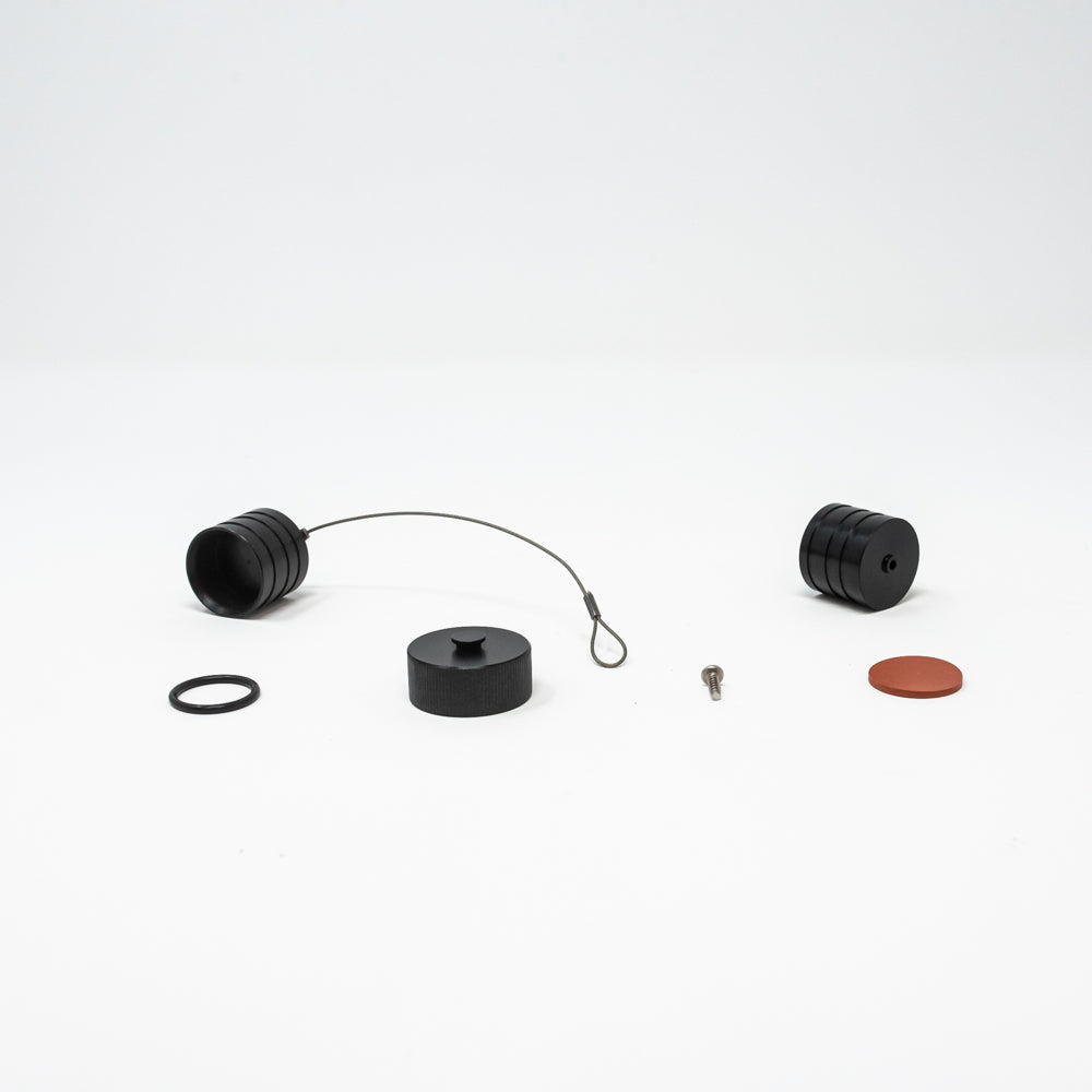 A close-up of black plastic caps and other small items, highlighting their materials and design on a simple surface.