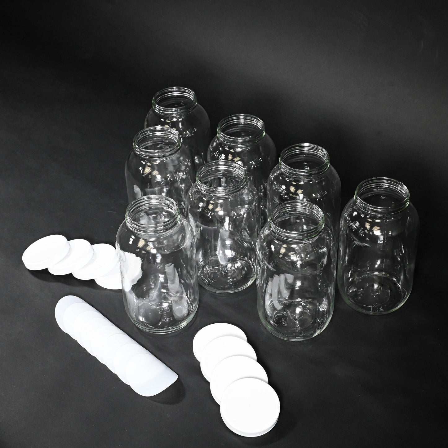 A set of glass bottles with caps displayed together, showcasing their clear glass design and simple elegance.