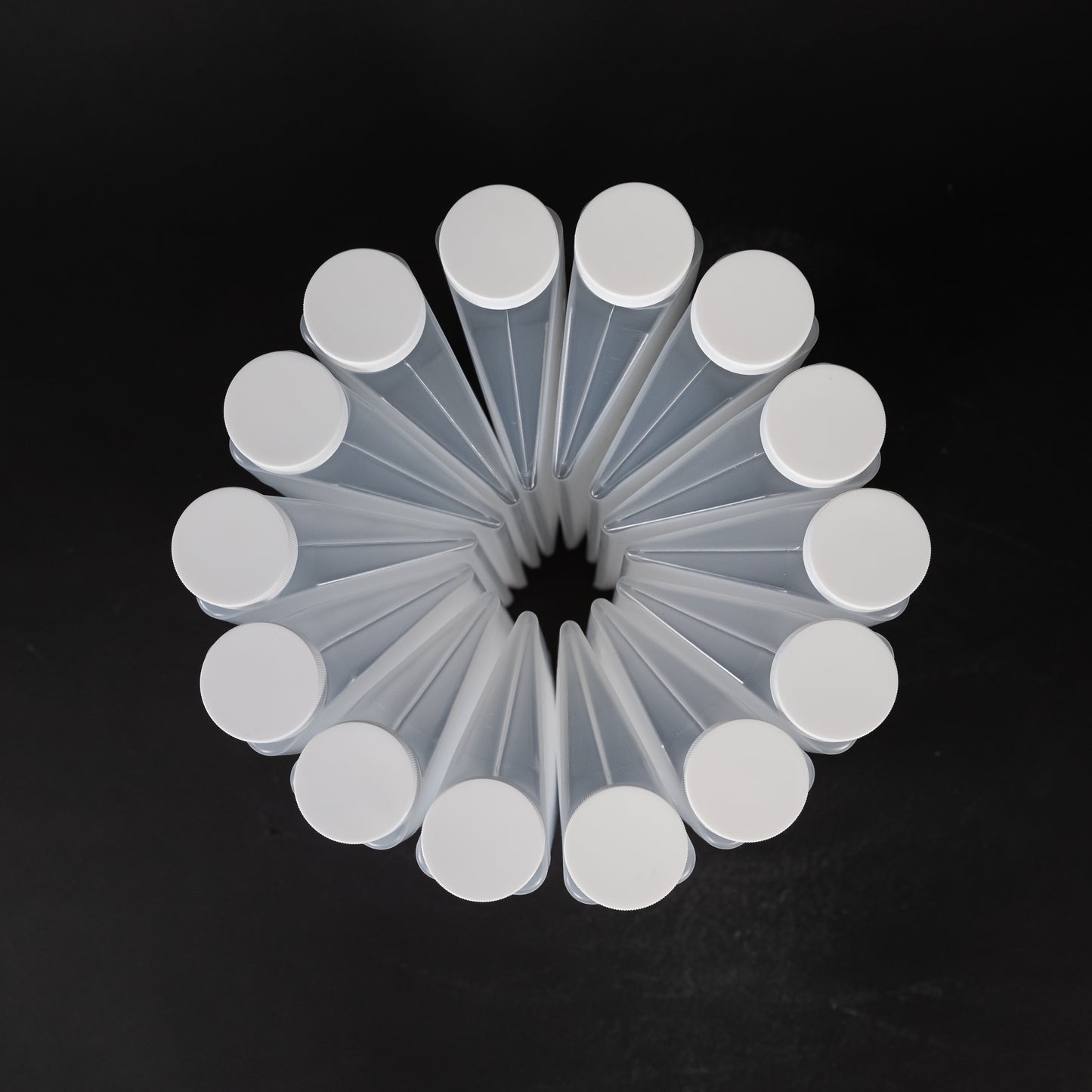 A collection of clear plastic bottles, each topped with a matching white cap, arranged neatly together.