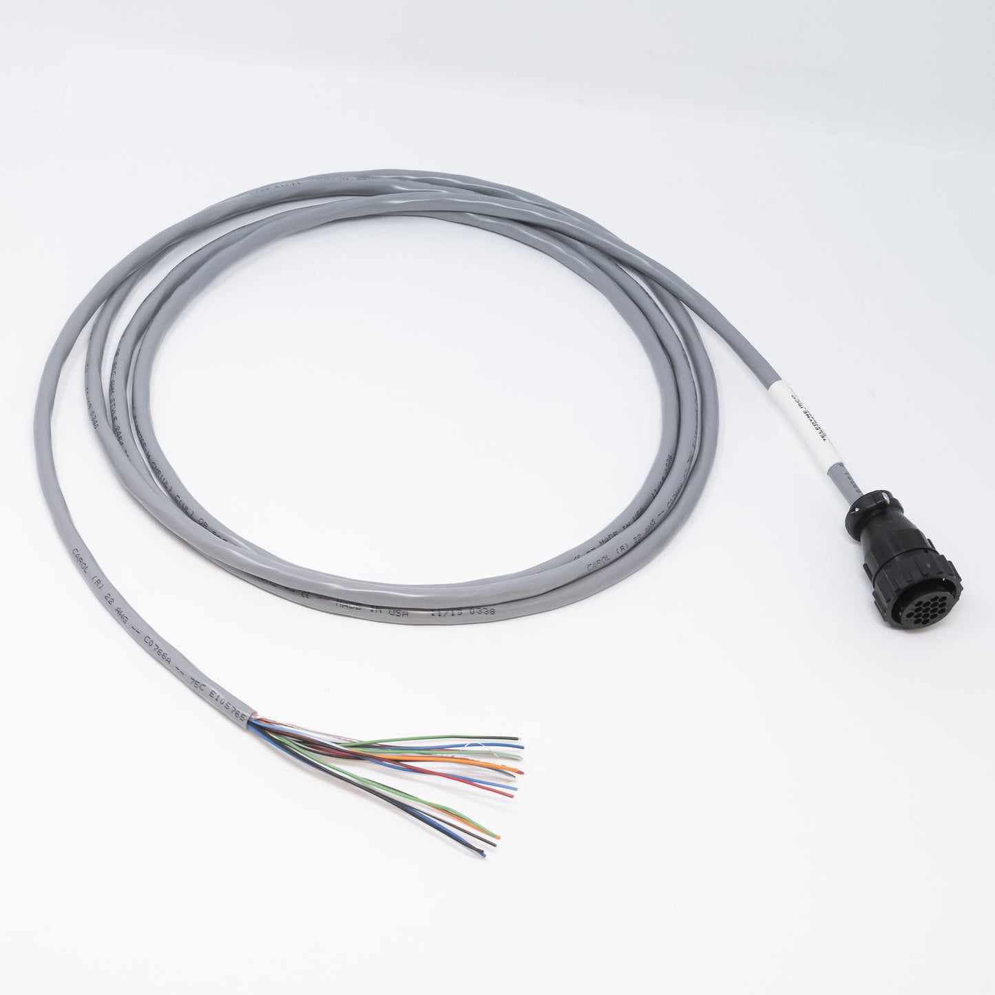 A coiled gray cable with a black connector on one end and exposed multicolored wires on the other end, placed on a white background.