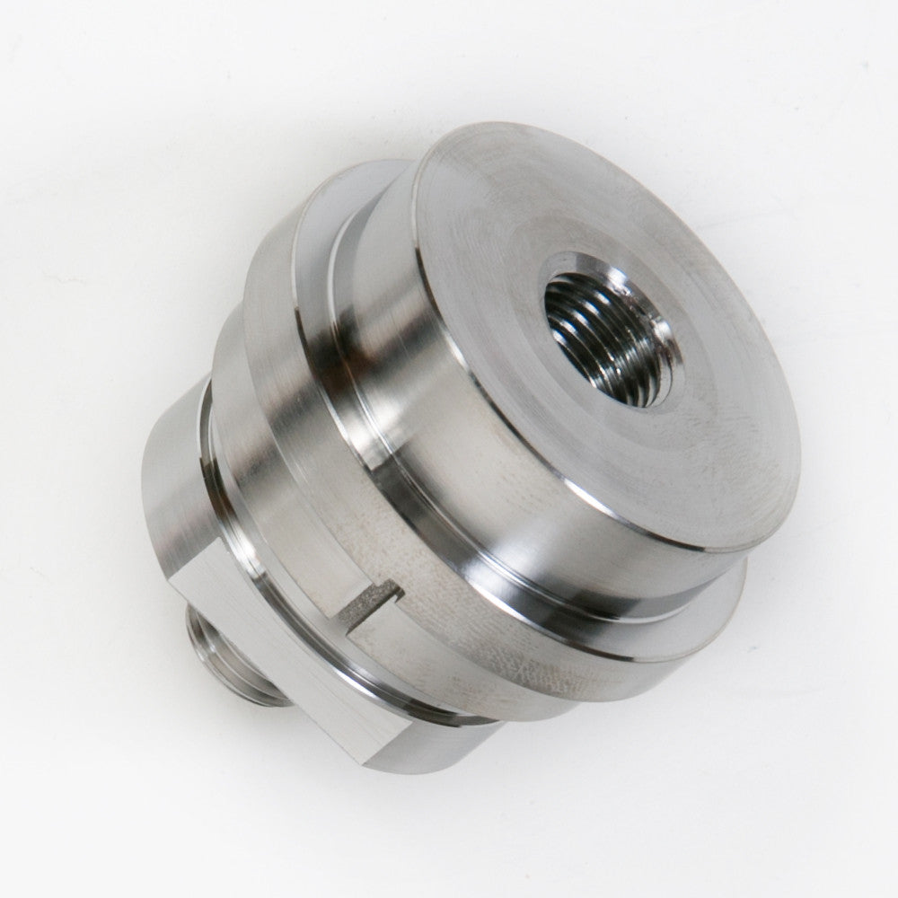 A round metallic item with a central opening, displaying a sleek surface and a minimalist aesthetic.